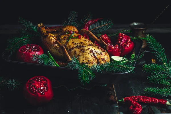 Christmas duck with pomegranates and lime surrounded by spruce branch — Stockfoto