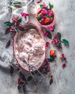 Strawberry ice cream balls with berries and mint leaves in white bowl