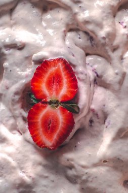 Strawberry ice cream balls with berries and mint leaves in white bowl