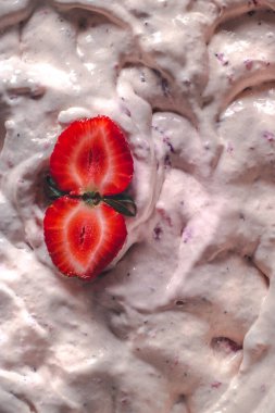 Strawberry ice cream balls with berries and mint leaves in white bowl