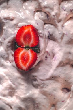 Strawberry ice cream balls with berries and mint leaves in white bowl