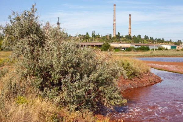 Technical settler of industrial water of mining industry in Kryvyi Rih, Ukraine. Redwater is polluted with iron ore waste. Discharge of process water in the sump after the iron ore beneficiation