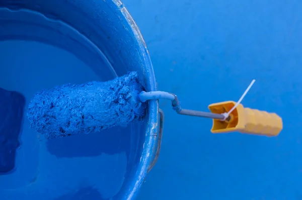 Paint can with blue color with orange paint roller — Stock Photo, Image