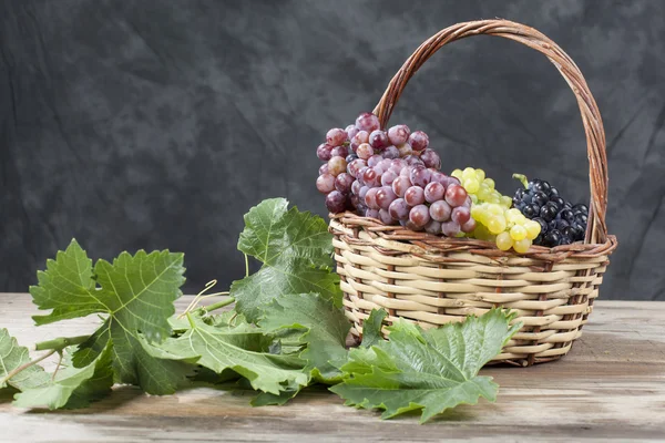 Bunch of white and red grape in a basket — Stock Photo, Image