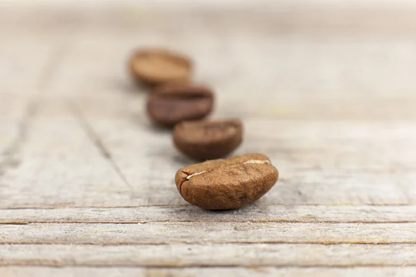 Grãos de café em fundo de madeira — Fotografia de Stock