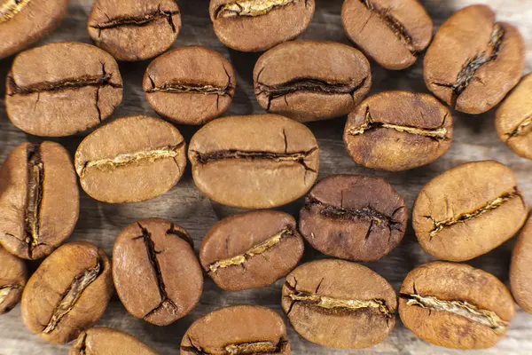 Granos de café sobre fondo de madera — Foto de Stock