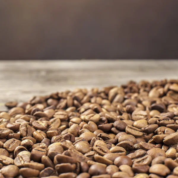 Granos de café sobre fondo de madera — Foto de Stock