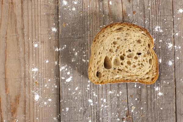 Slice of bread on wooden background — Stock Photo, Image