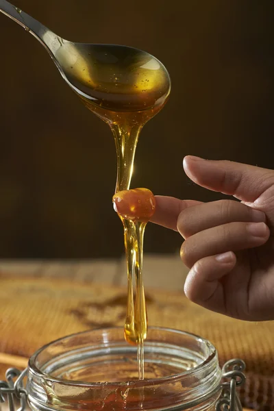 Honey dripping from a spoon — Stock Photo, Image