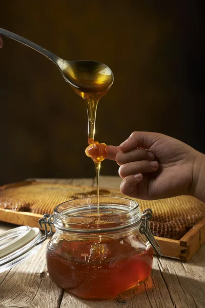 Honey dripping from a spoon — Stock Photo, Image