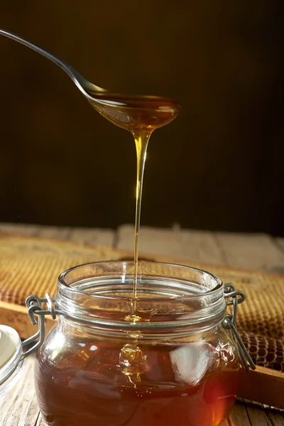 Honey dripping from a spoon — Stock Photo, Image