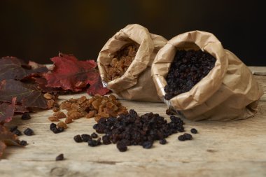 kağıt torba ahşap bir masa üzerinde altın ve siyah kuru üzüm