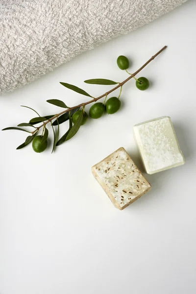Handgemaakte Olijfzeep met olijftak en een handdoek. — Stockfoto