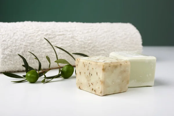 Jabón de oliva hecho a mano con rama de olivo y toalla . —  Fotos de Stock