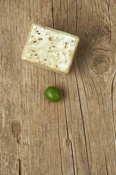 Handgjorda oliv tvål med en grön oliv på träbord. — Stockfoto