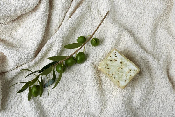 Sabão de azeitona feito à mão com ramo de azeitona e uma toalha . — Fotografia de Stock