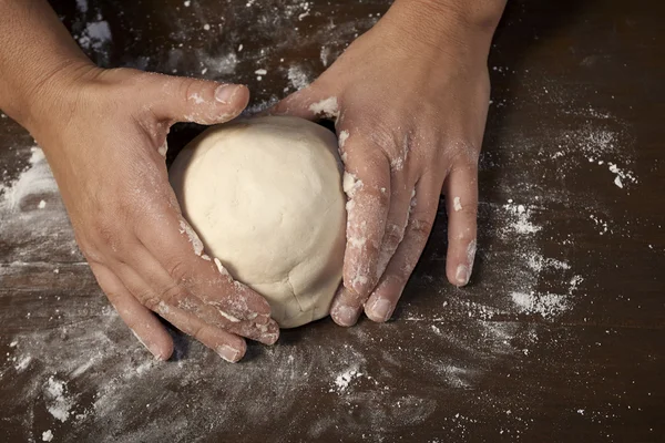 Woman's hands kneading dough on wooden table — Stock Photo, Image