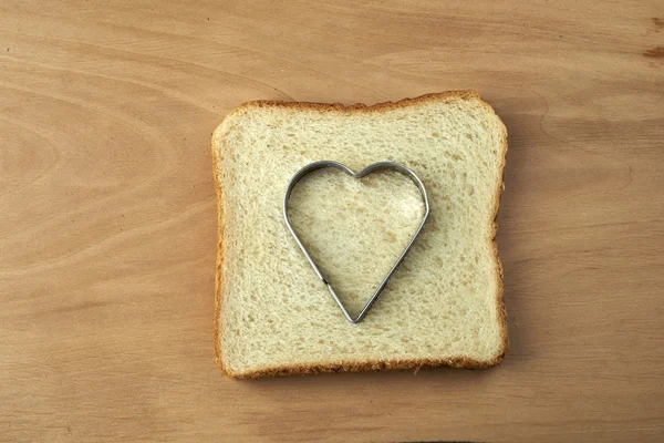 Kalp şekli dışarı kesim ile ekmek dilimi — Stok fotoğraf