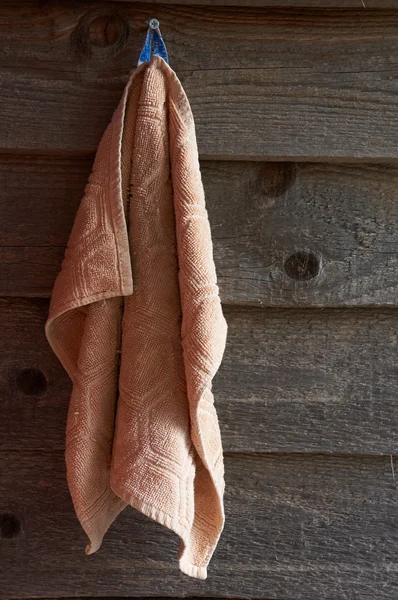 Toalha de rosto pendurada em uma parede de madeira — Fotografia de Stock