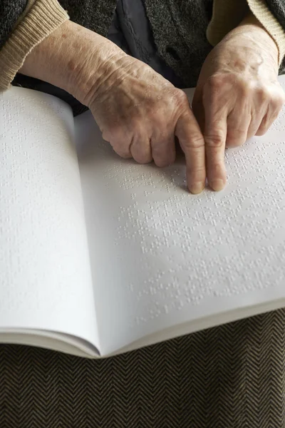 Old womans hands, reading a book with braille language — Stock Photo, Image