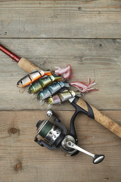 Colorful lures with the fishing rod on the wooden pier — Stock Photo, Image