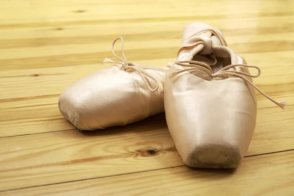 Dvojice baletní boty pointes na dřevěnou podlahu — Stock fotografie