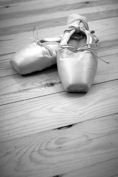 Dvojice baletní boty pointes na dřevěnou podlahu — Stock fotografie