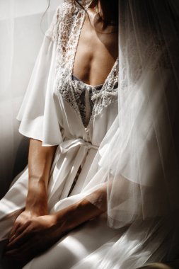 Gelinlikli güzel gelin pencerenin yanında oturuyor.