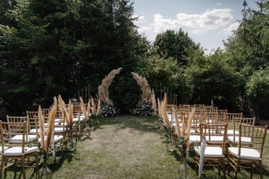 Beyaz sandalyeli ve çiçekli düğün kemeri