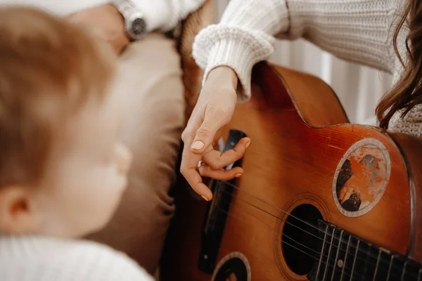 mother playing guitar to her child