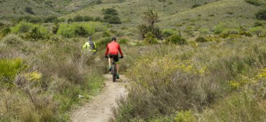 Bisikletçiler Cartagena, Murcia 'daki Calblanque Doğal Parkı' nda spor yapıyorlar..