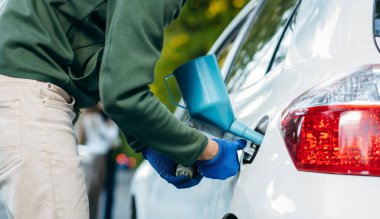 Genç adam boş yakıt deposunu plastik bir kutudan benzin dökmek için hazırla..