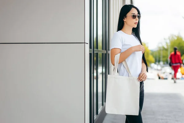 街上的年轻亚洲模特儿拿着白色的生态包 模仿着 — 图库照片