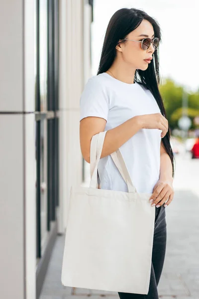 Sokaktaki Genç Asyalı Manken Kız Elinde Beyaz Bir Çanta Tutuyor Stok Fotoğraf