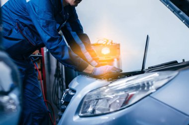 Otomobil elektrikçisinin ellerini bilgisayar kullanarak araba motorlarının tamir ve onarım için parçalarını kontrol etmek ve teşhis etmek için kapat