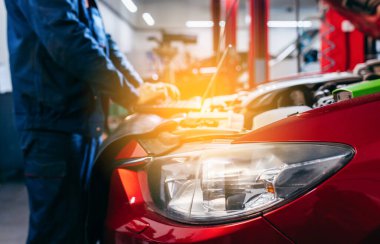 Otomatik elektrikçi, tamir ve onarım için araba motorlarının parçalarını tanımlamak ve kontrol etmek için bir bilgisayar bilgisayarı kullanıyor.