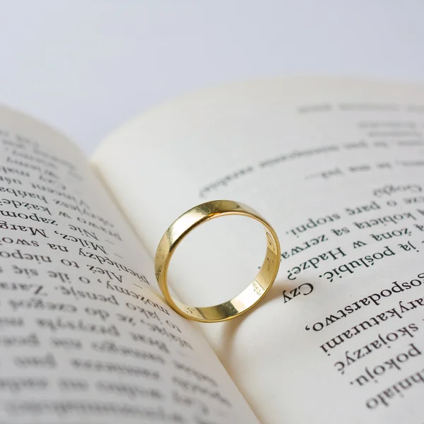 Close up of wedding ring lying on an open book — Stock Photo, Image