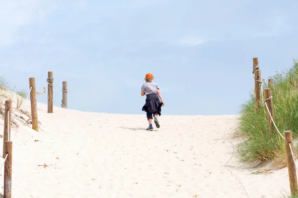 The lonely boy walking through a sand dune — Stock Photo, Image
