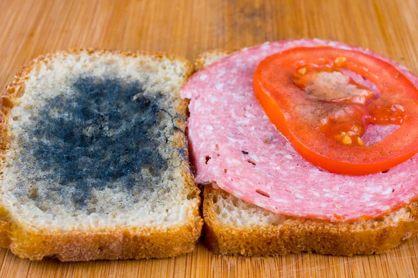 かびの生えたサンドイッチ サラミ、まな板トマト — ストック写真