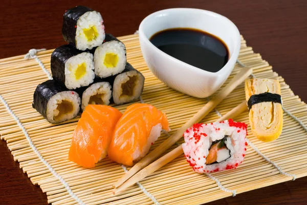 Sushi in row on bamboo mat — Stock Photo, Image