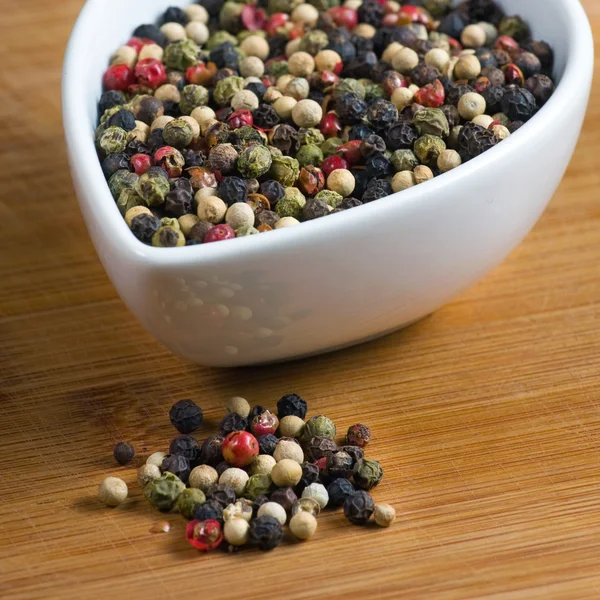 Peppercorns on a wooden board — Stock Photo, Image