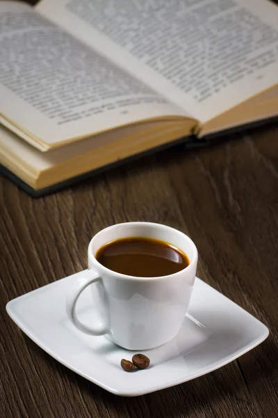 Zwarte sterke koffie op de tabel en lezen boek — Stockfoto