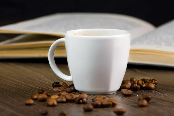 Schwarzer starker Kaffee auf dem Tisch und Lesebuch — Stockfoto