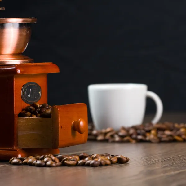 Coffee antique grinder, coffee beans and cup of coffee. Stock Picture