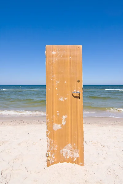 Open deur naar strand en blauwe zee — Stockfoto