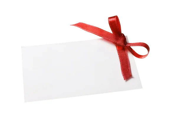 Blank gift tag tied with a bow of red satin ribbon. Isolated on white, with soft shadow — Stock Photo, Image