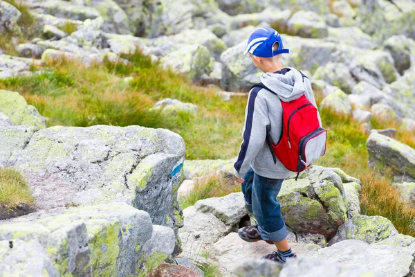 Rapaz cruzando um caminho rochoso — Fotografia de Stock