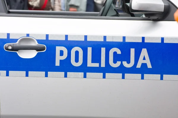 Cartel de la policía polaca en una puerta del coche de policía — Foto de Stock