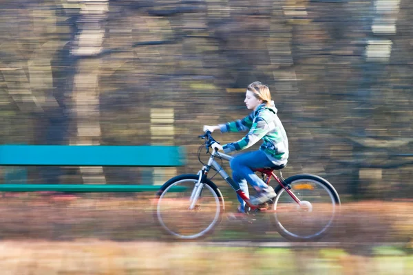 Mountain biking in a park - Young biker on a park biking trail going fast (motion blurred image) — Stock Photo, Image