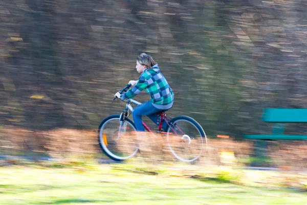 Mountain biking in a park - Young biker on a park biking trail going fast (motion blurred image)